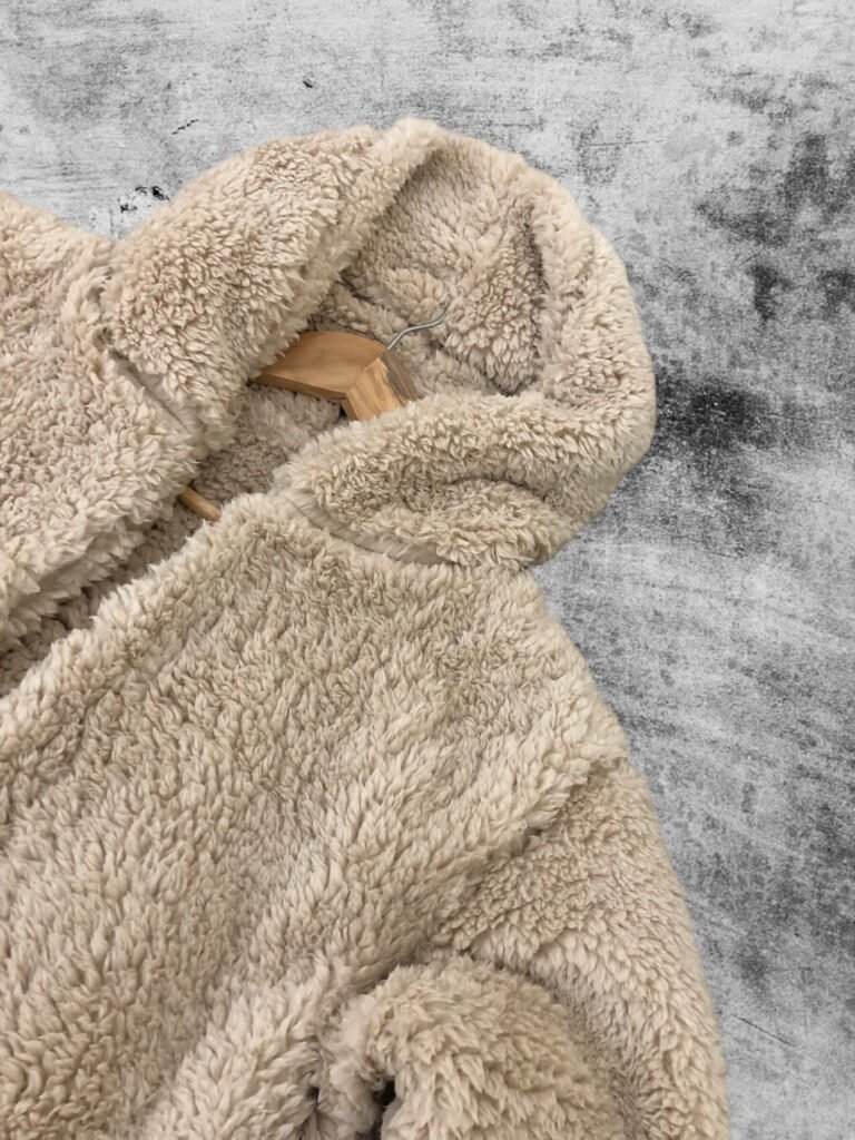 Close-up of the hood and neckline of a taupe fleece hoodie