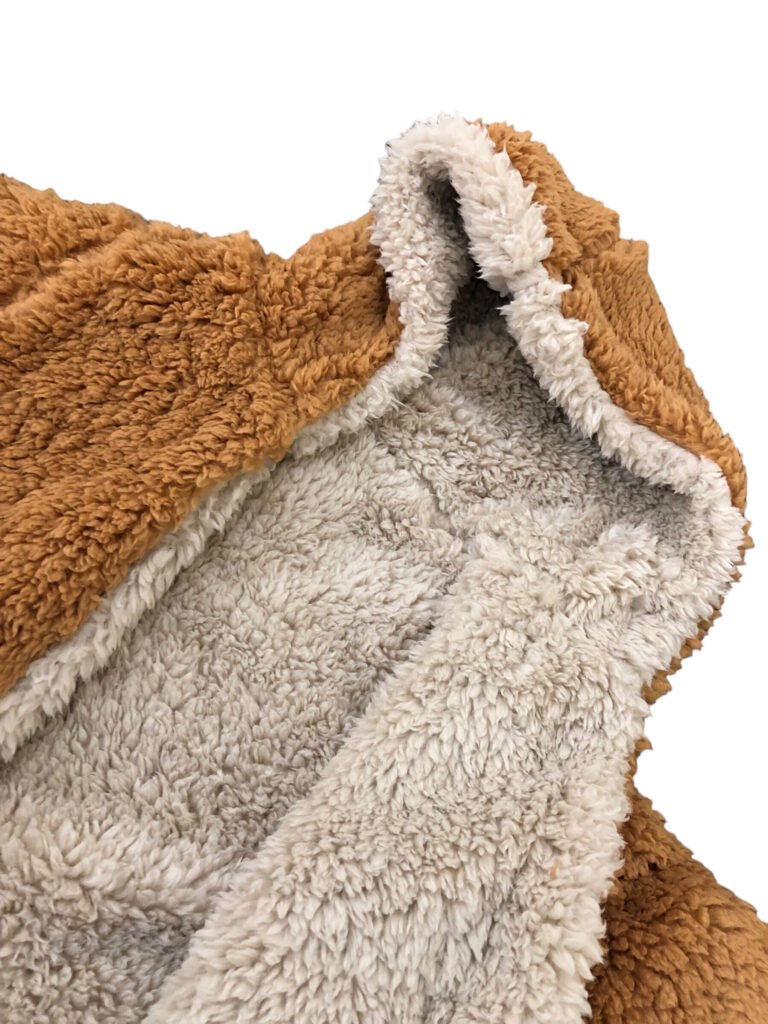 Close-up of tan and cream fleece fabric around a jacket opening