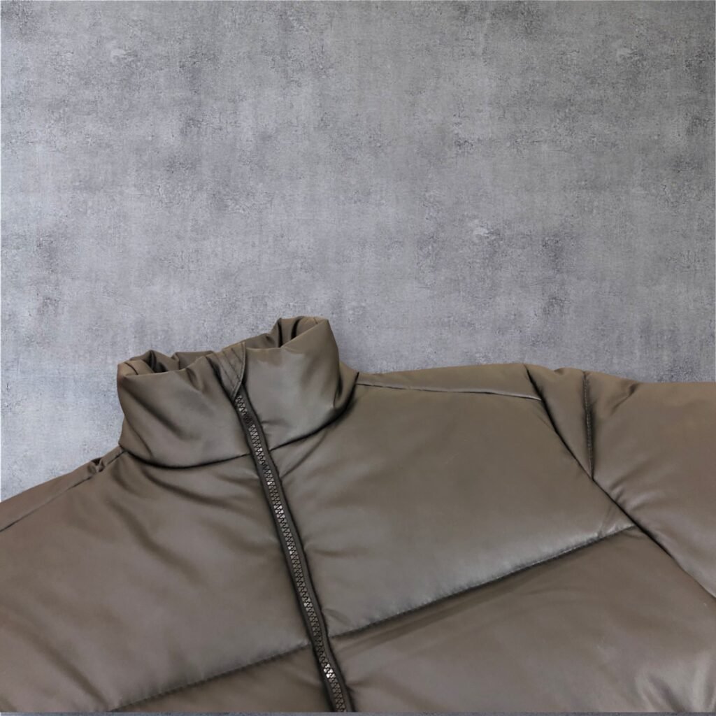 Close-up of the collar and zip on a taupe padded jacket.