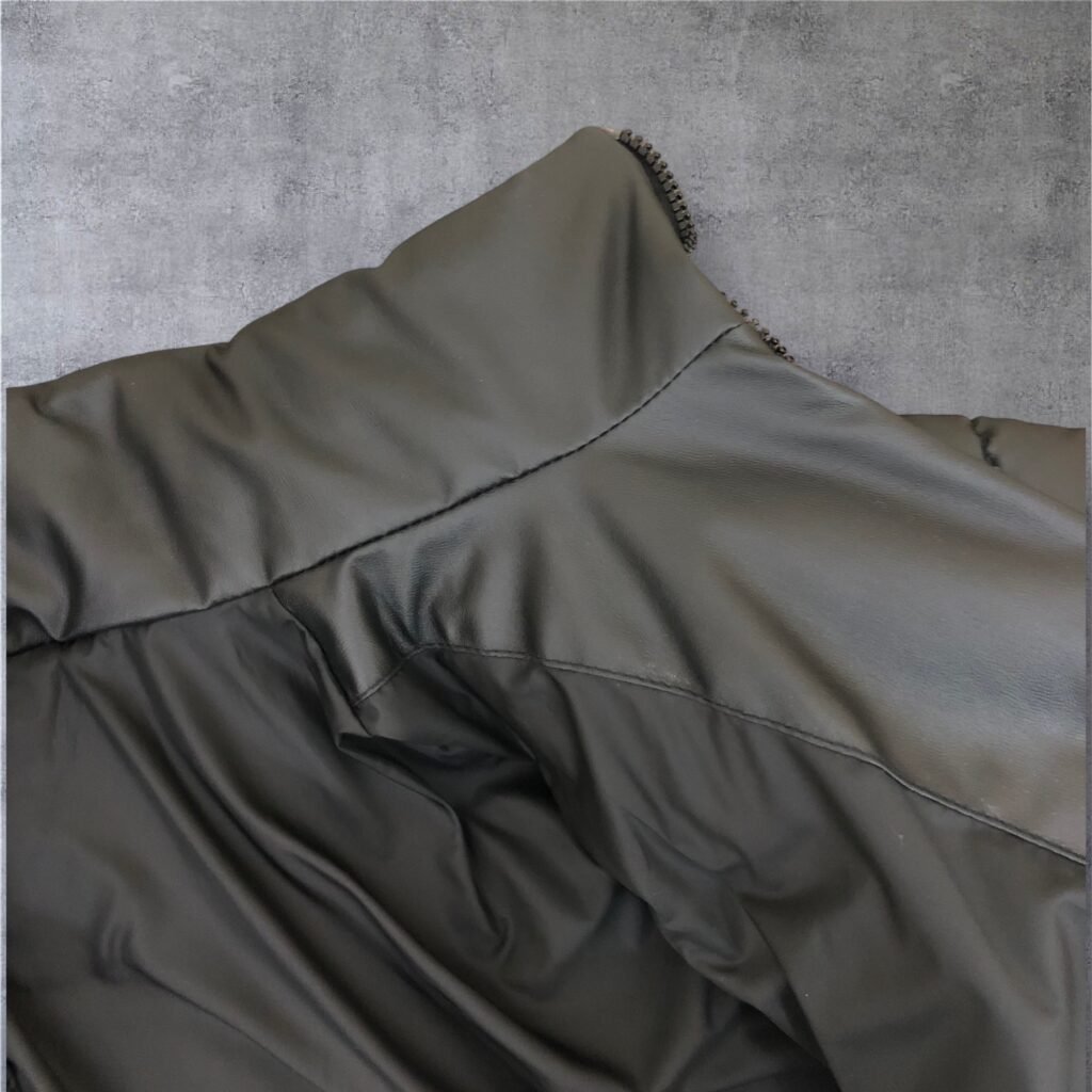 Close-up of the stand collar and shoulder panel of an olive jacket