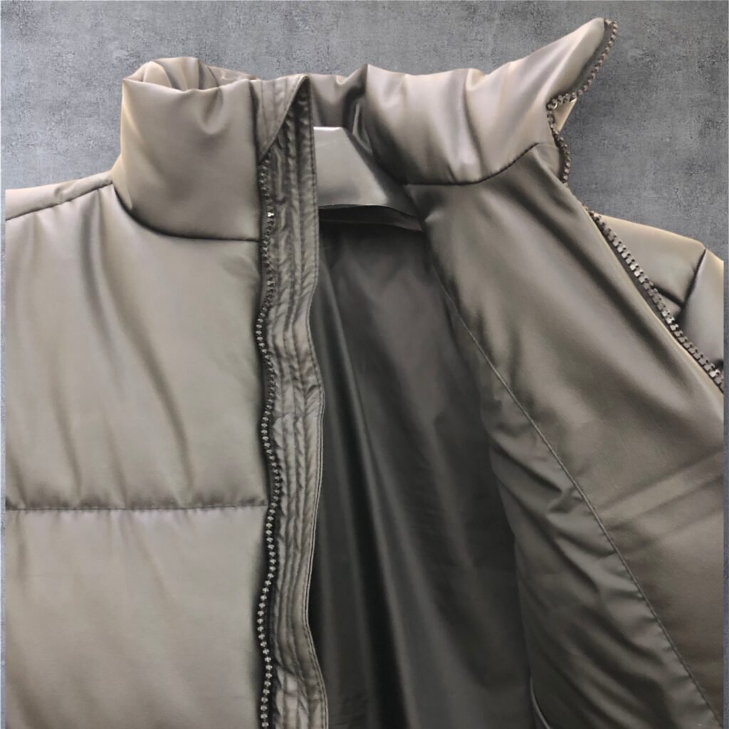 Close-up of the front zipper and stand collar of an olive puffer jacket
