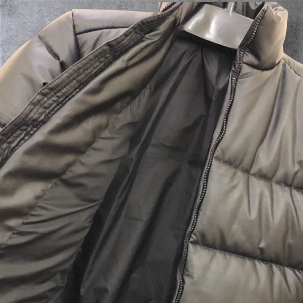 Close-up of the lining and front zipper of an olive puffer jacket