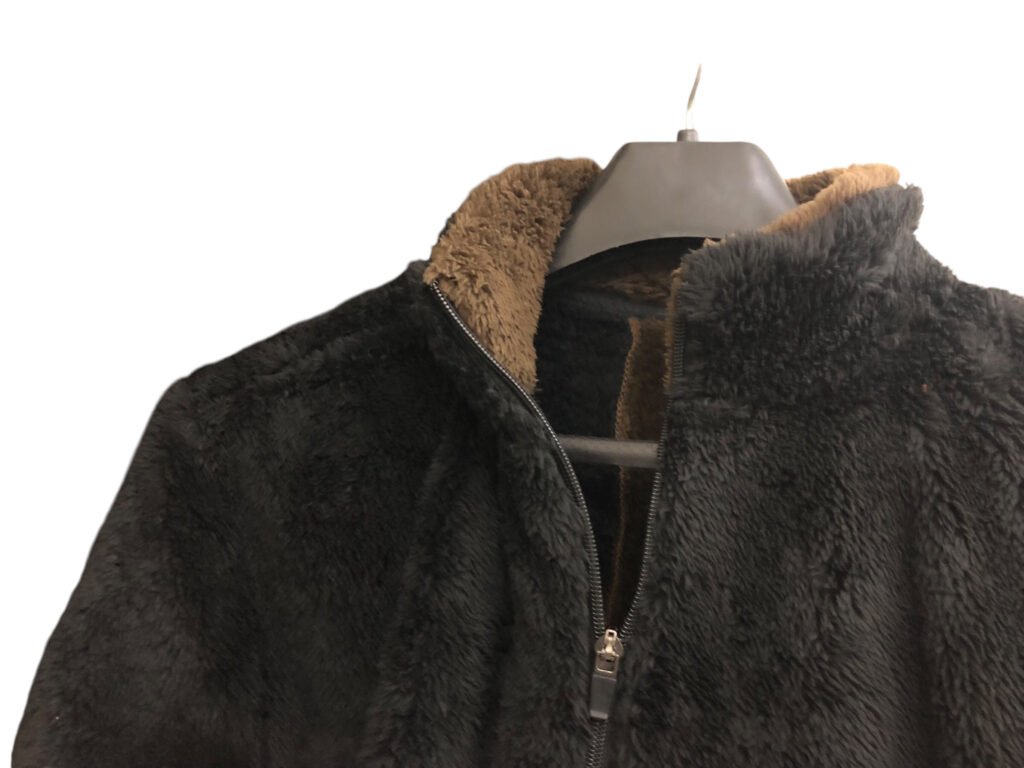 Close-up of the collar and zip on a dark grey fleece pullover.
