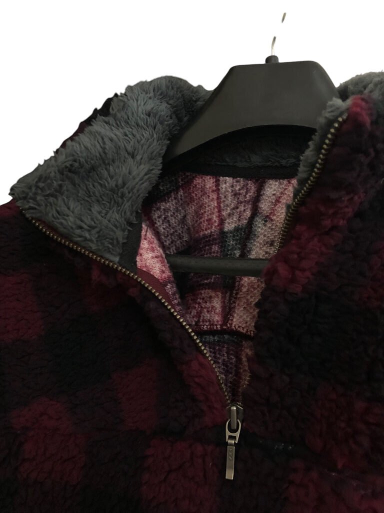 Close-up of the collar and zip on a red and black check fleece pullover.