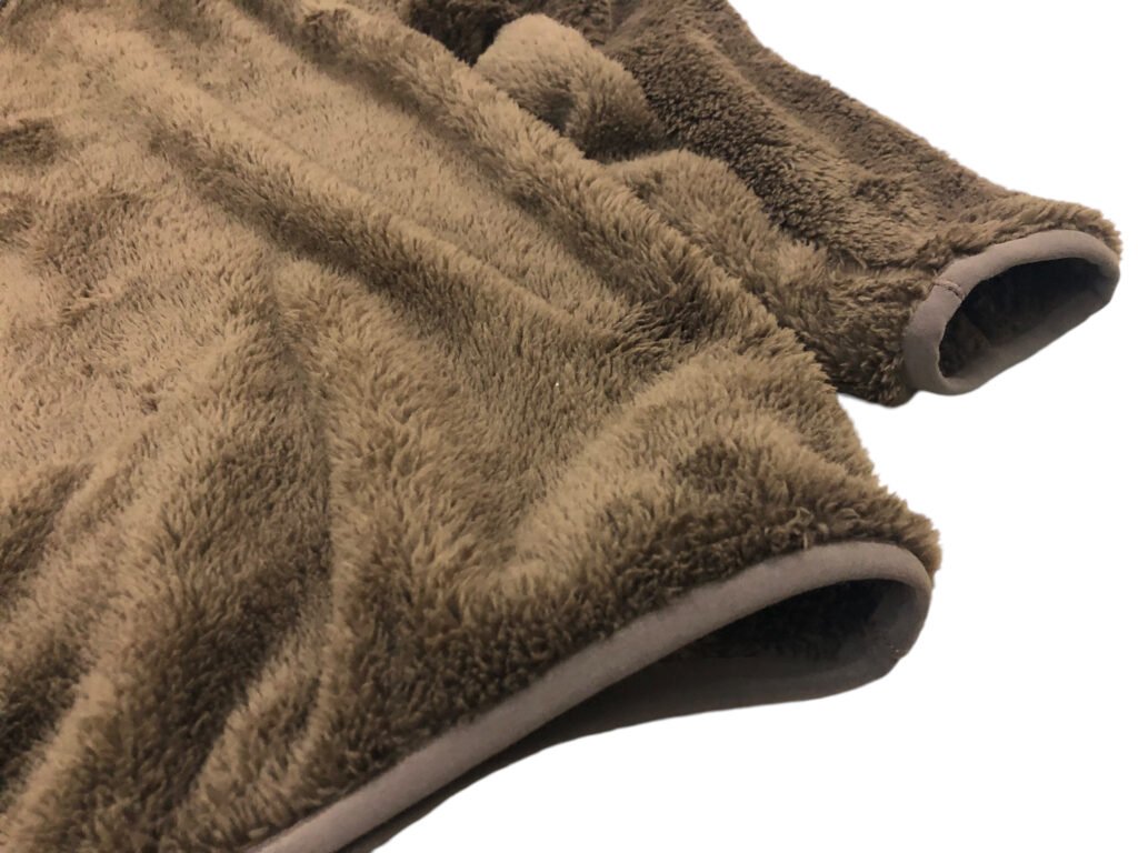 Close-up of the sleeves and hems on a brown fleece pullover.