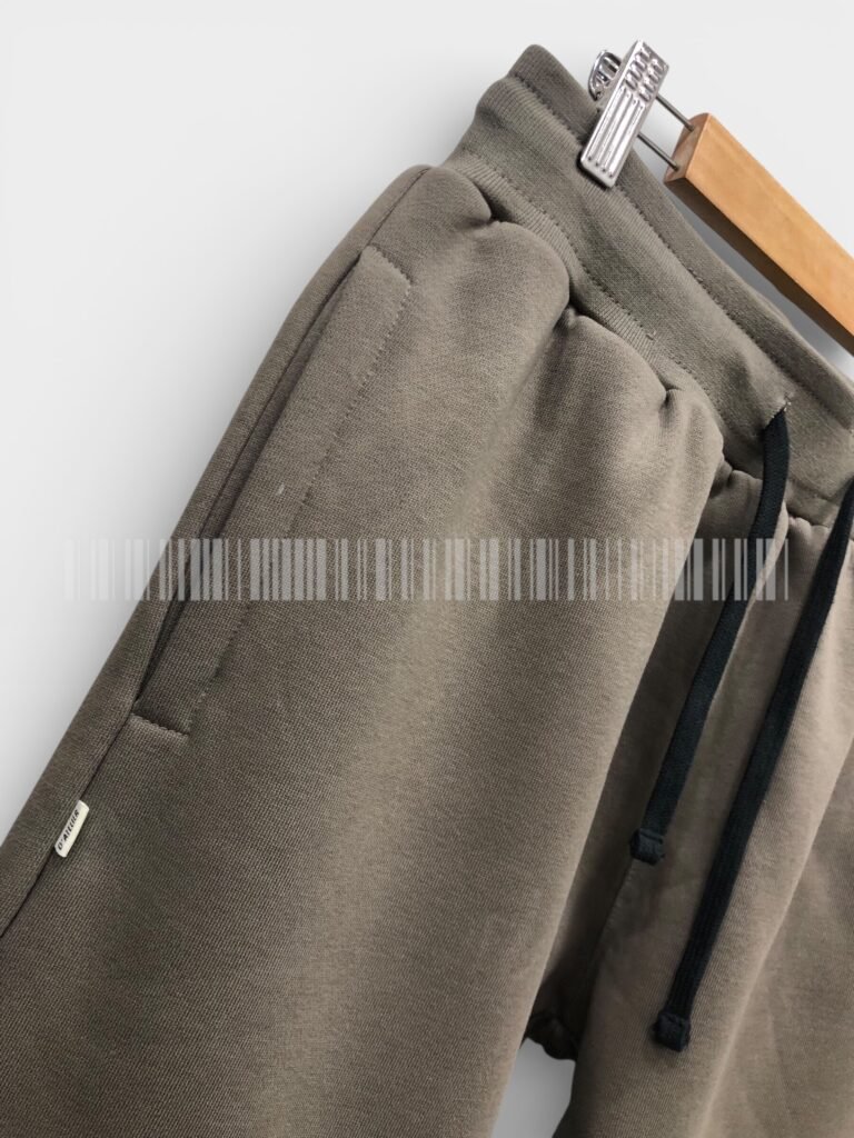 Close-up of the side pocket on brown joggers.