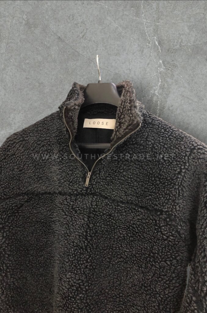 Close-up of the collar and zip on a dark grey fleece pullover.
