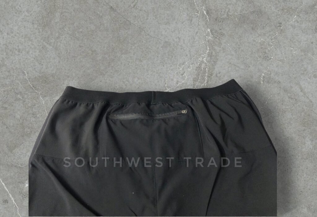 Close-up of the elastic waistband on black athletic shorts.