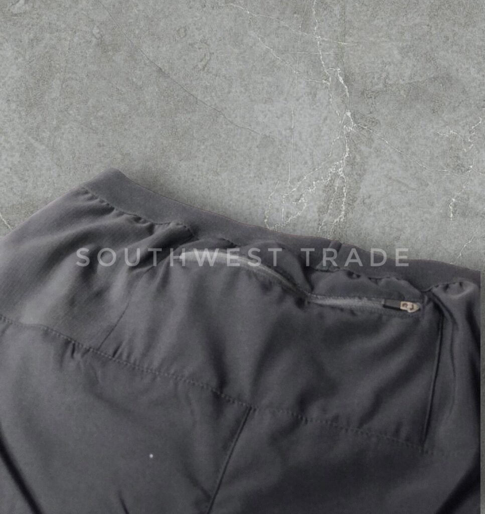 Close-up of the waistband stitching on black athletic shorts.