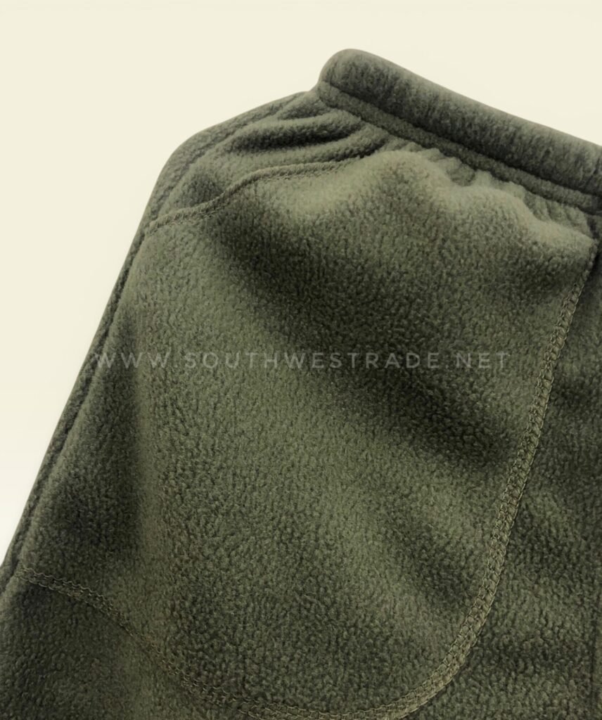 Close-up of a pocket seam on olive green joggers.