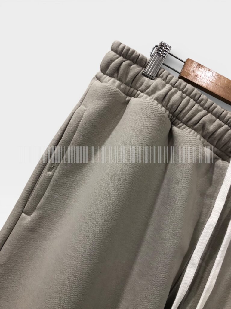 Close-up of the side pocket on light grey joggers.