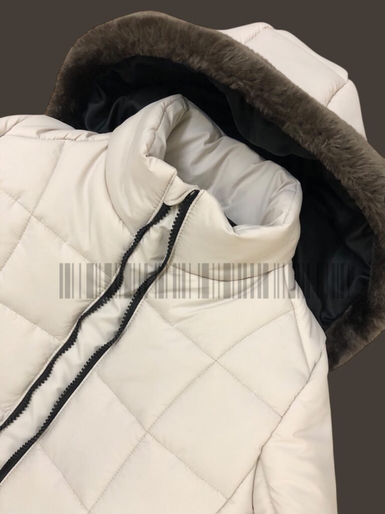 Close-up of the hood and collar on an off-white padded jacket.