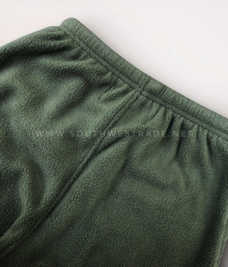 Close-up of the elastic waistband on olive green joggers.