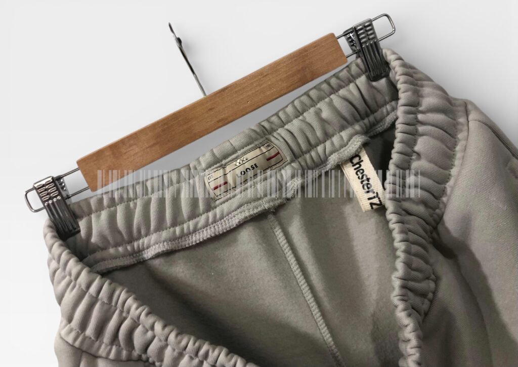 Close-up of the waistband and drawstring on light grey joggers.