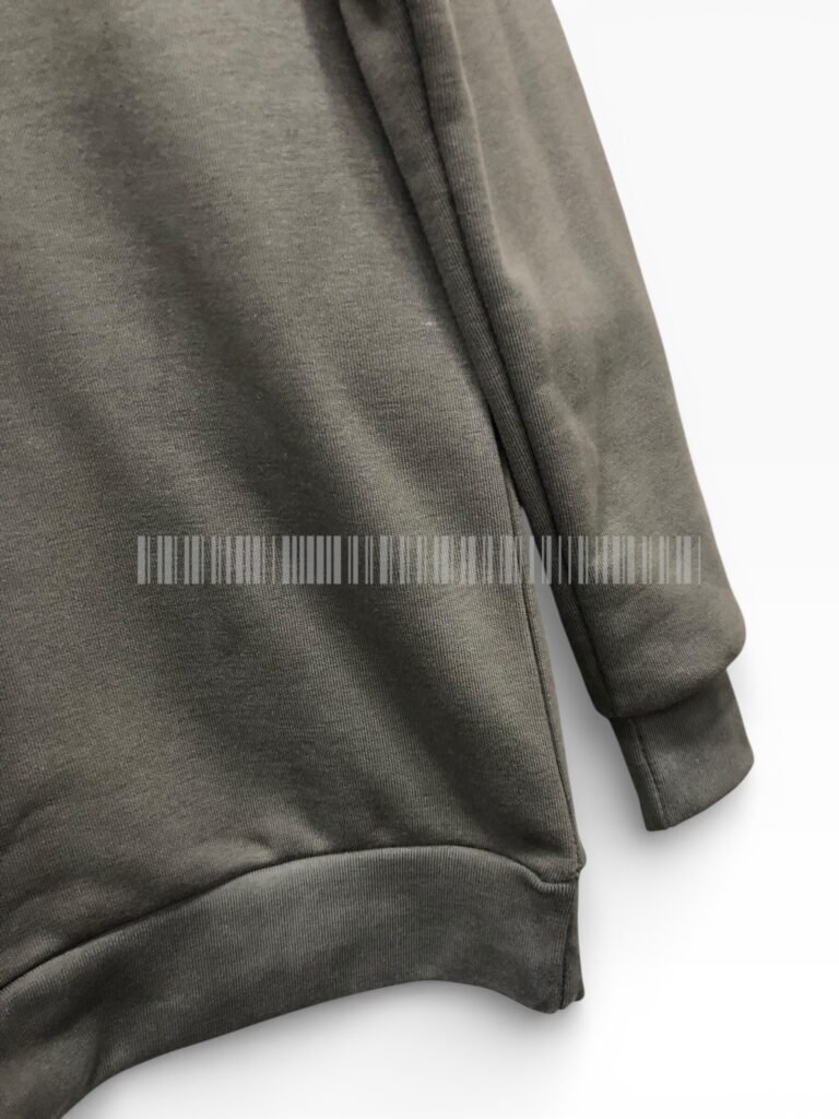 Close-up of the ribbed cuff and hem on a charcoal sweatshirt.
